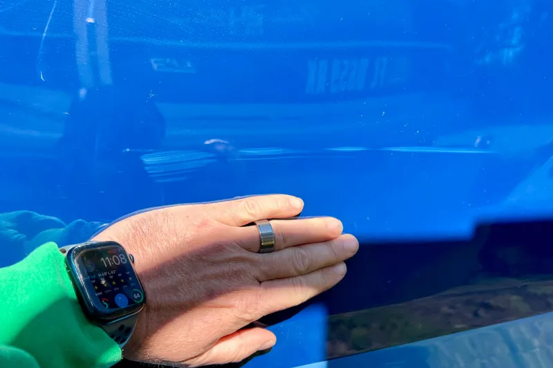 Slide: The Image of Hand touching blue hull of 2024 Sea Ray SLX 280 Outboard boat. - 82