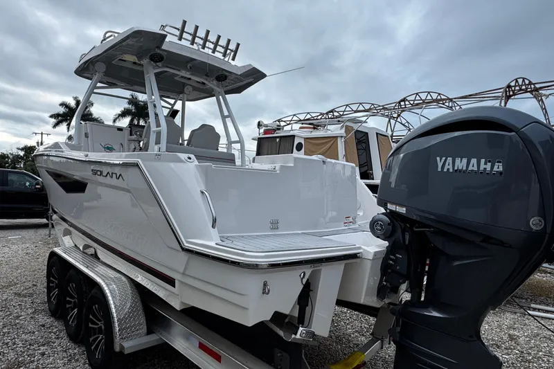 Slide: The Image of 2024 Solara S-250 CW boat with Yamaha engine on trailer, parked outdoors. - 1