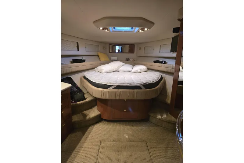 Slide: The Image of 1999 Sea Ray 550 Sedan Bridge interior with white seating, cushions, and open storage compartments. - 14