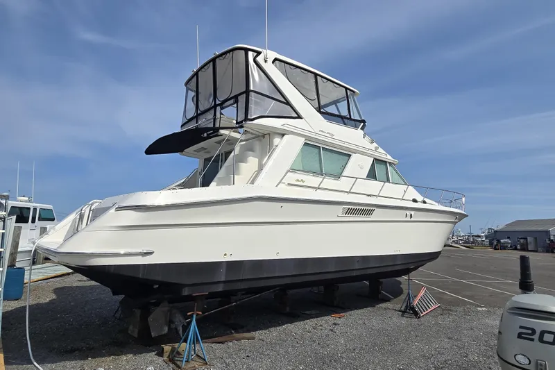 Slide: The Image of 1999 Sea Ray 550 Sedan Bridge yacht on dry dock under clear sky. - 2