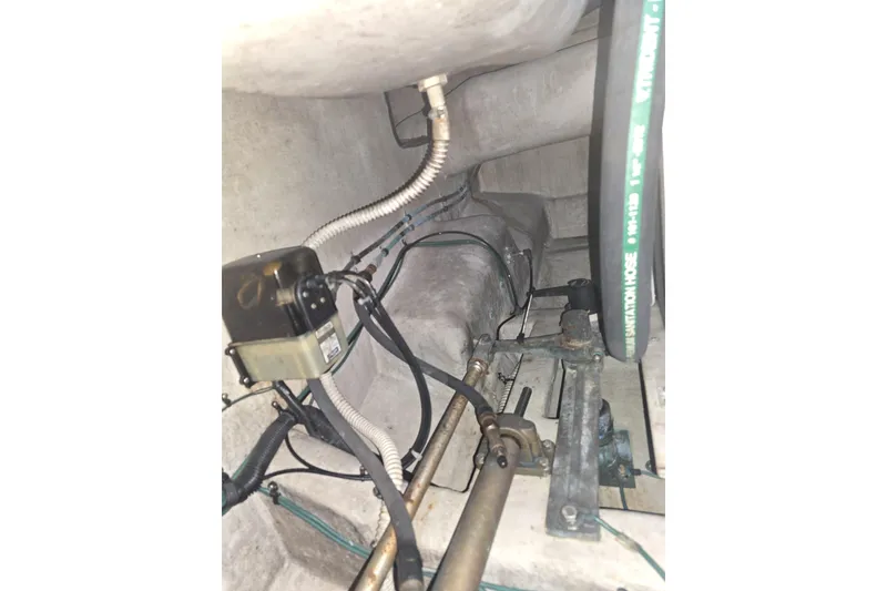 Slide: The Image of Engine room of 1999 Sea Ray 550 Sedan Bridge with visible machinery and piping. - 49