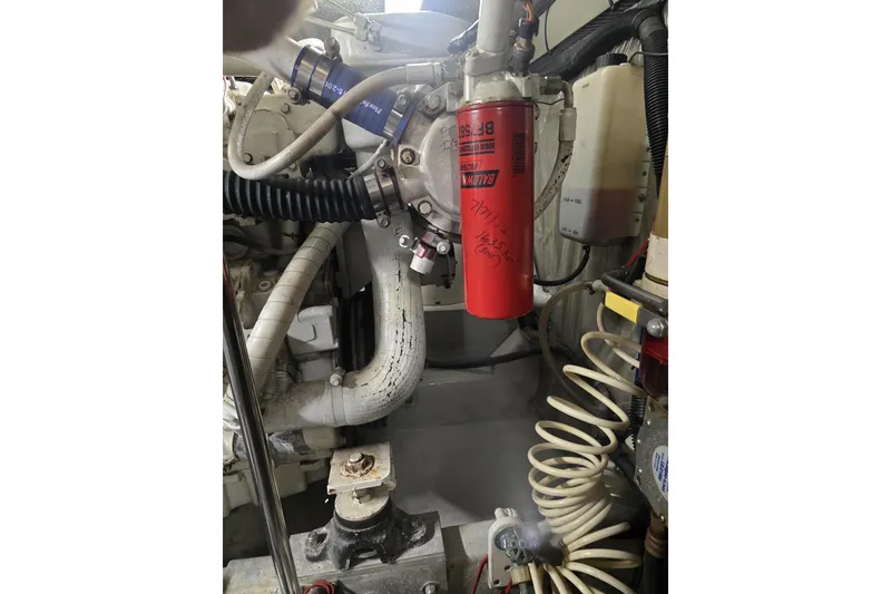 Slide: The Image of Engine room of a 1999 Sea Ray 550 Sedan Bridge with visible hoses and filter. - 61