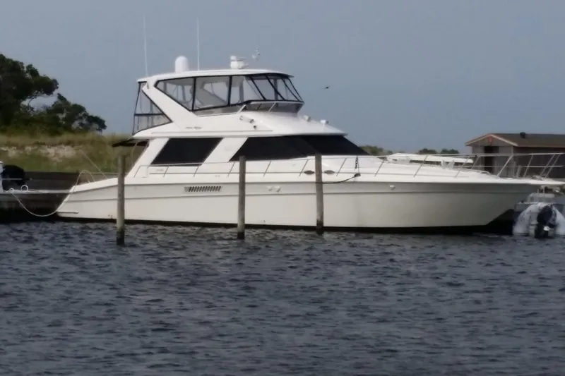 Slide: The Image of 1998 Sea Ray 550 Sedan Bridge yacht docked by the shore. - 63