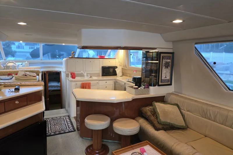 Slide: The Image of 1998 Sea Ray 550 Sedan Bridge yacht interior with panoramic windows and plush seating. - 9