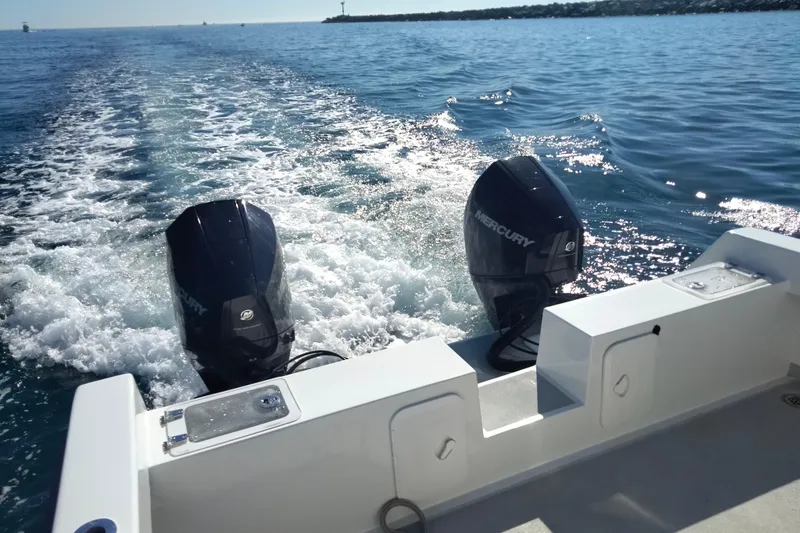 Slide: The Image of 2021 Custom Pilot House Catamaran with dual Mercury outboard engines cruising on open water. - 15