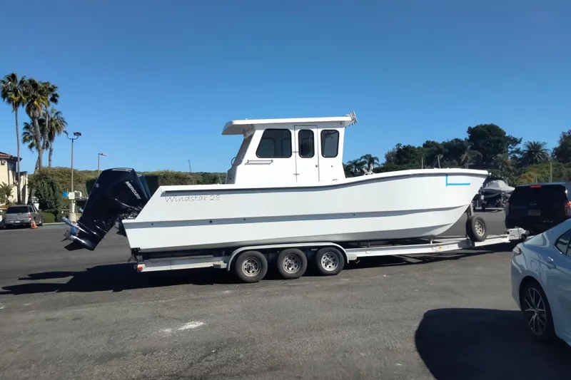 Slide: The Image of 2021 Custom Pilot House Catamaran on trailer in parking lot, clear sky background. - 18