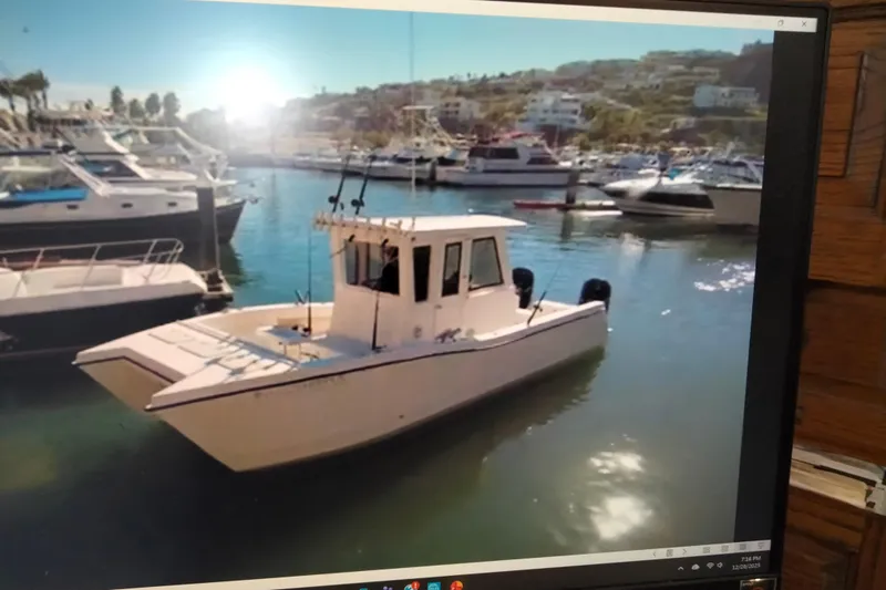 Slide: The Image of 2021 28 Custom Line Pilot House Catamaran docked in a sunny marina. - 3