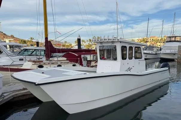 Slide: The Image of Custom 2021 Pilot House Catamaran docked in marina, surrounded by other boats. - 8