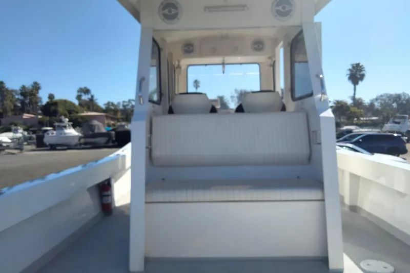 Slide: The Image of Custom 2021 Pilot House Catamaran with seating, docked under clear blue sky. - 9