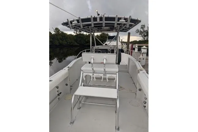 Slide: The Image of 2000 Glacier Bay 260 Canyon Runner boat with seating and canopy, docked near trees. - 15