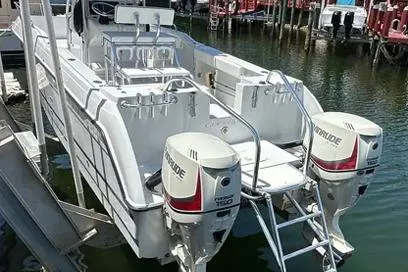 Slide: The Image of 2000 Glacier Bay 260 Canyon Runner boat with twin Evinrude engines docked in marina. - 18