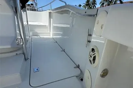 Slide: The Image of 2000 Glacier Bay 260 Canyon Runner boat deck with clean white finish and palm trees in background. - 24