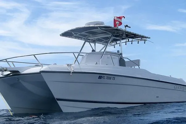 Slide: The Image of 2000 Glacier Bay 260 Canyon Runner boat on open water, featuring a sleek design and canopy. - 4