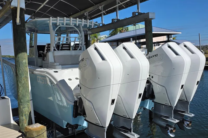 Slide: The Image of 2024 Costa Custom Boats 34 SV with four powerful outboard engines docked by the water. - 13