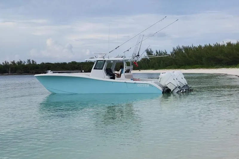 Slide: The Image of 2024 Costa Custom Boats 34 SV cruising at sunset with powerful outboard engines. - 2