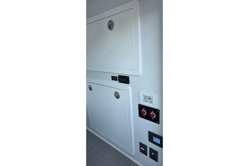 Slide: The Image of 2024 Costa Custom Boats 34 SV interior panel with controls and storage compartments. - 44