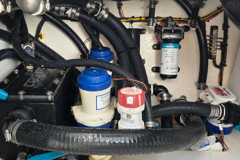 Slide: The Image of Engine compartment of 2024 Costa Custom Boats 34 SV, showcasing hoses and components. - 68