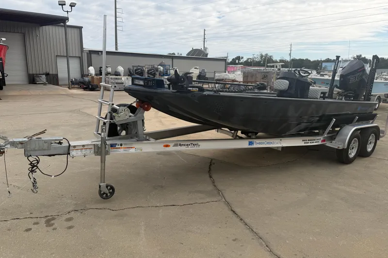 Slide: The Image of 2025 Timber Creek 2064 boat on trailer in industrial setting. - 12