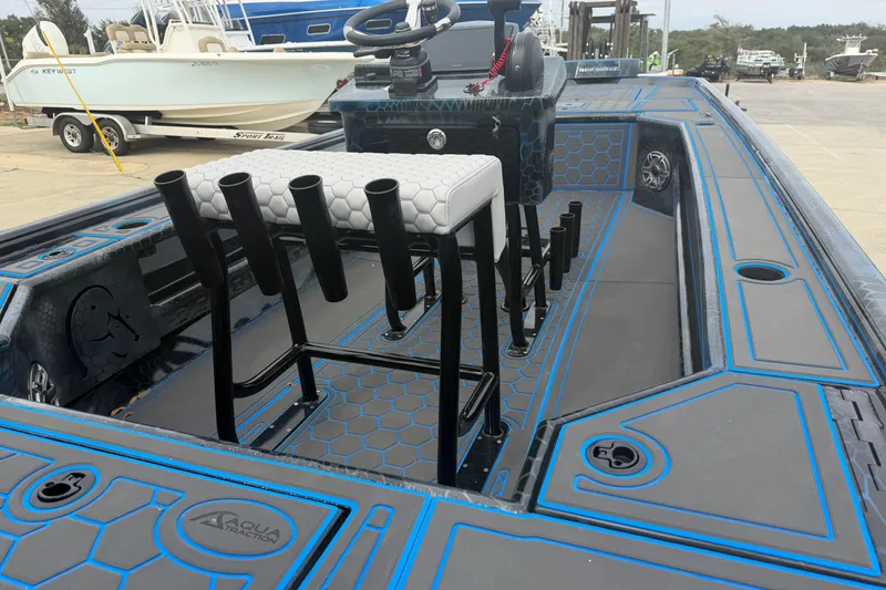 Slide: The Image of 2025 Timber Creek 2064 boat interior with blue accents and rod holders at a marina. - 26