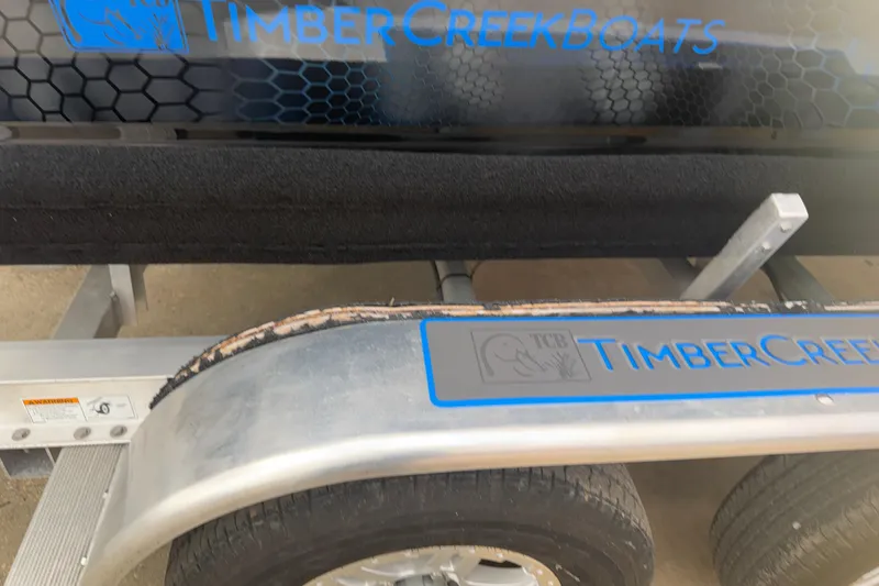 Slide: The Image of Trailer for 2025 Timber Creek 2064 boat with logo and hexagonal pattern design. - 4