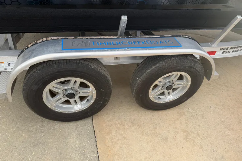 Slide: The Image of Trailer with dual wheels, Timber Creek Boats branding, model 2064, year 2025. - 5