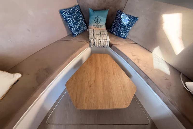 Slide: The Image of Interior of 2023 NX Boats 360 Sport Coupe with cozy seating and decorative pillows. - 15