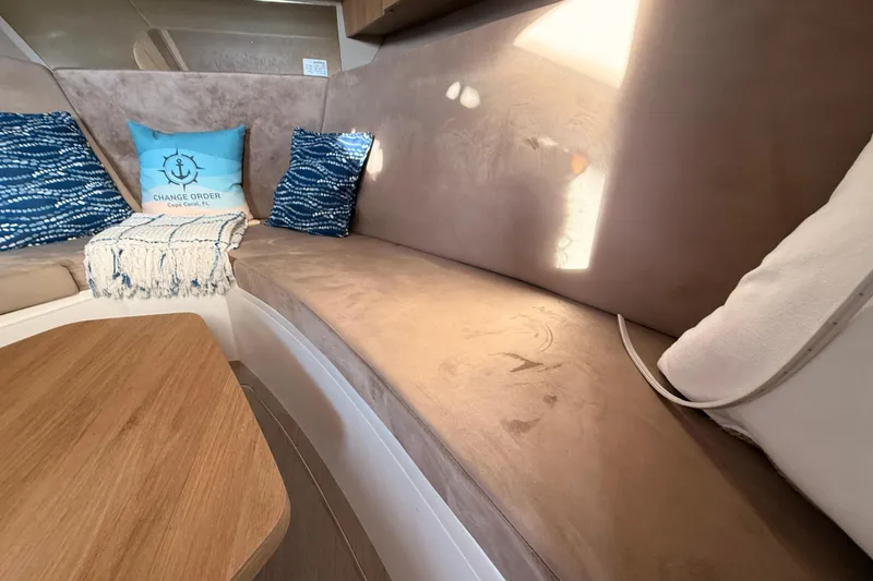 Slide: The Image of Interior of 2023 NX Boats 360 Sport Coupe with cozy seating and decorative pillows. - 17