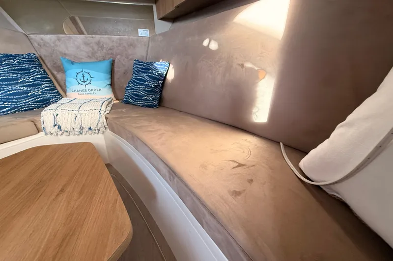 Slide: The Image of Interior of 2023 NX Boats 360 Sport Coupe with cozy seating and decorative pillows. - 18