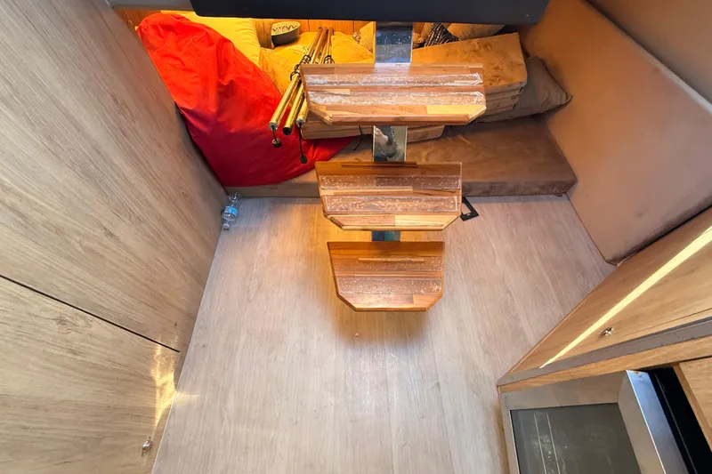 Slide: The Image of Interior of 2023 NX Boats 360 Sport Coupe with wooden steps and cozy seating area. - 19