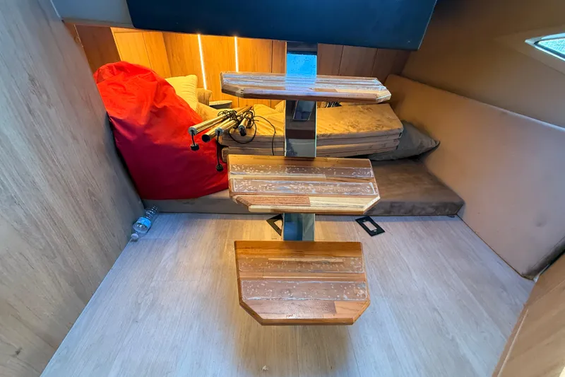 Slide: The Image of Interior of 2023 NX Boats 360 Sport Coupe with wooden stairs and cozy seating area. - 20