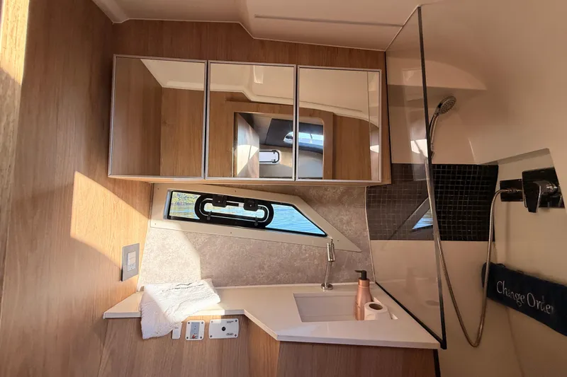 Slide: The Image of Luxurious bathroom in 2023 NX Boats 360 Sport Coupe with modern fixtures and wood accents. - 26