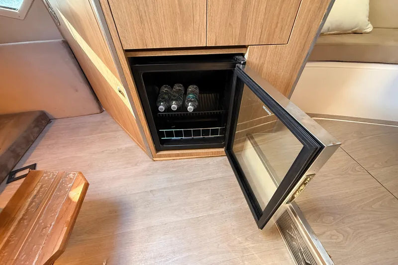 Slide: The Image of Mini fridge with water bottles inside NX Boats 360 Sport Coupe, 2023 model. - 28