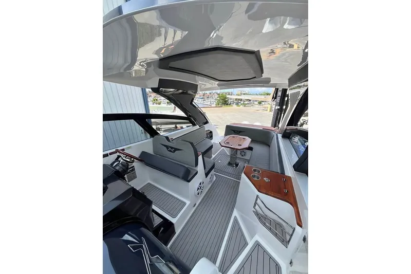 Slide: The Image of 2023 NX Boats 360 Sport Coupe with dual engines, docked in a marina. - 3