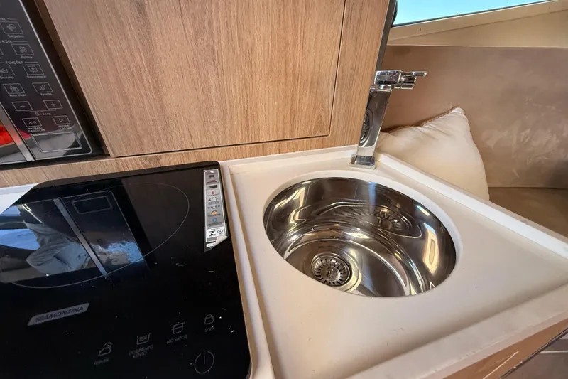 Slide: The Image of Modern kitchen area in 2023 NX Boats 360 Sport Coupe with sink and cooktop. - 31