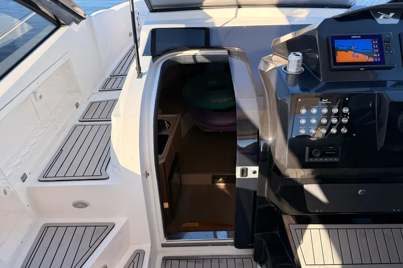 Slide: The Image of 2023 NX Boats 360 Sport Coupe cockpit with navigation controls and cabin entrance. - 32