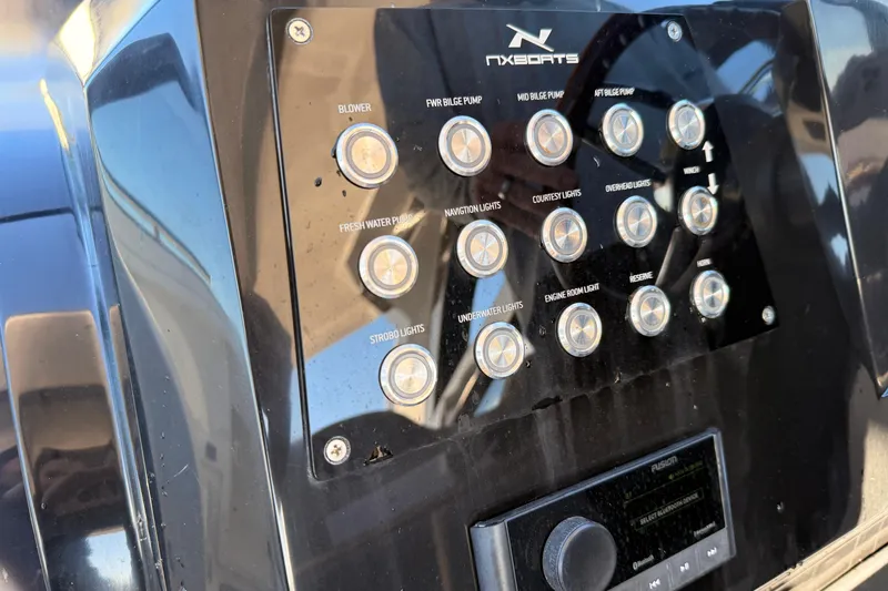 Slide: The Image of Control panel of 2023 NX Boats 360 Sport Coupe with labeled buttons and switches. - 34