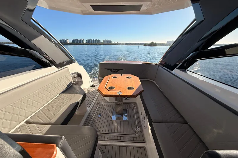 Slide: The Image of Luxurious interior of 2023 NX Boats 360 Sport Coupe with elegant seating and scenic water view. - 38