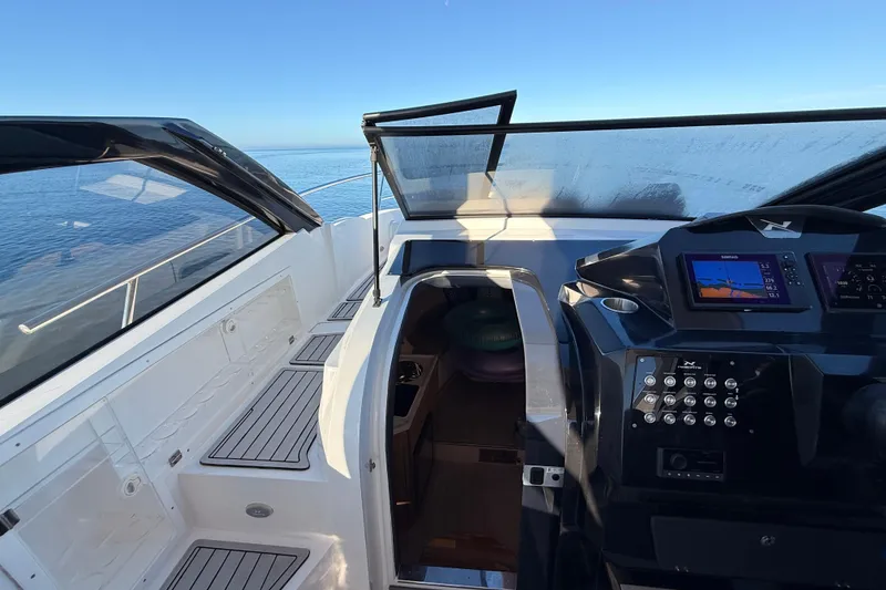 Slide: The Image of 2023 NX Boats 360 Sport Coupe cockpit with modern controls and ocean view. - 44