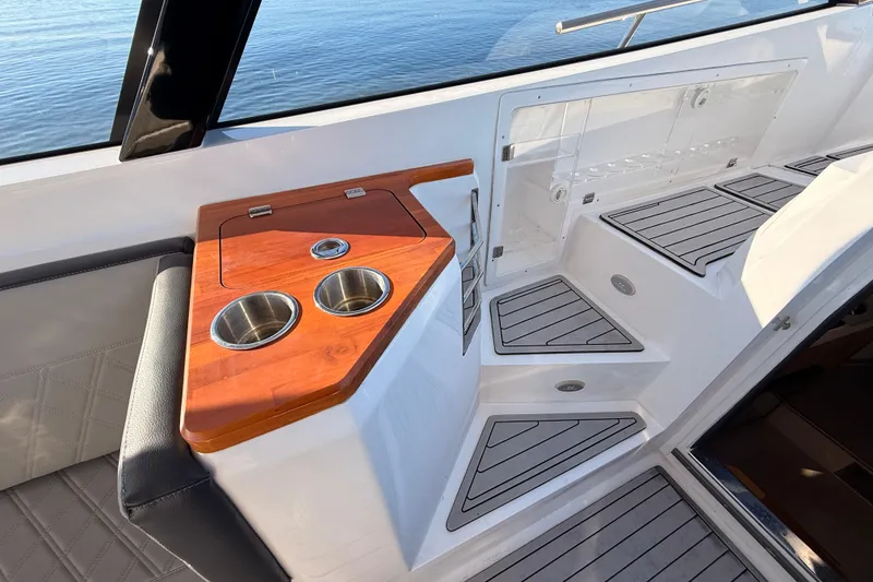 Slide: The Image of 2023 NX Boats 360 Sport Coupe interior with wood accents and cup holders. - 46