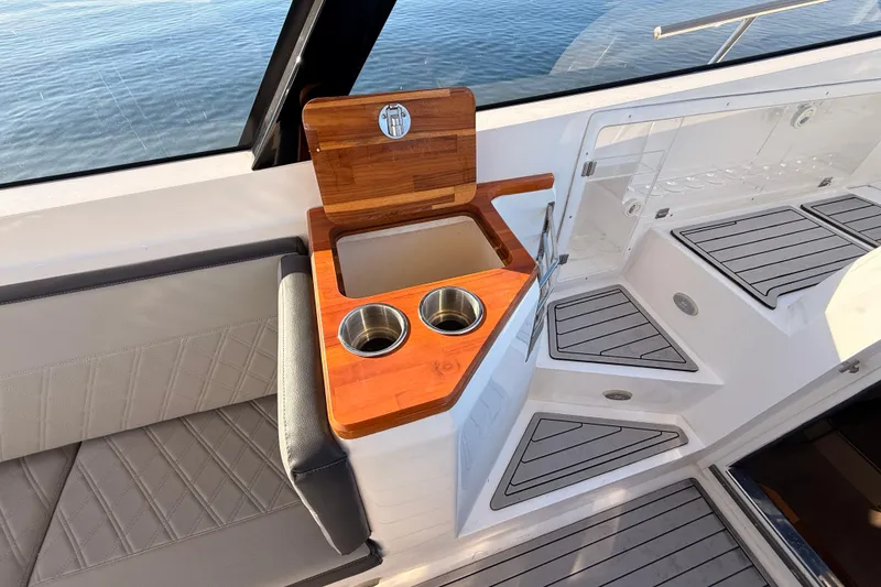 Slide: The Image of 2023 NX Boats 360 Sport Coupe interior with wooden cup holders and seating. - 47