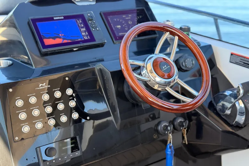 Slide: The Image of Helm of 2023 NX Boats 360 Sport Coupe with wooden steering wheel and control panel. - 50