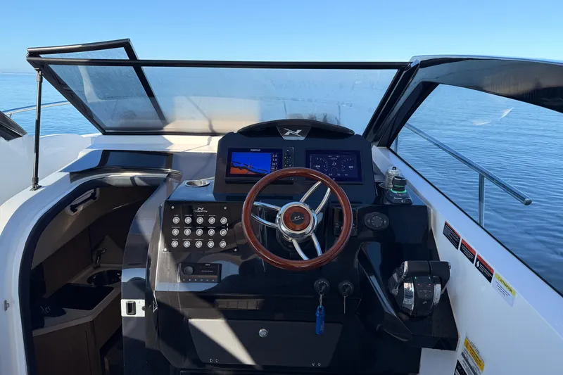 Slide: The Image of 2023 NX Boats 360 Sport Coupe helm with modern controls and ocean view. - 52