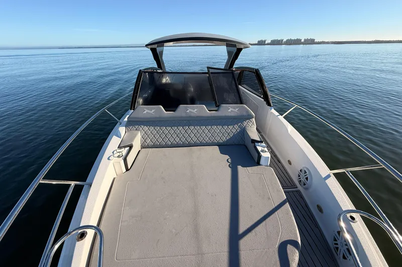 Slide: The Image of 2023 NX Boats 360 Sport Coupe on calm water, showcasing spacious deck and sleek design. - 61