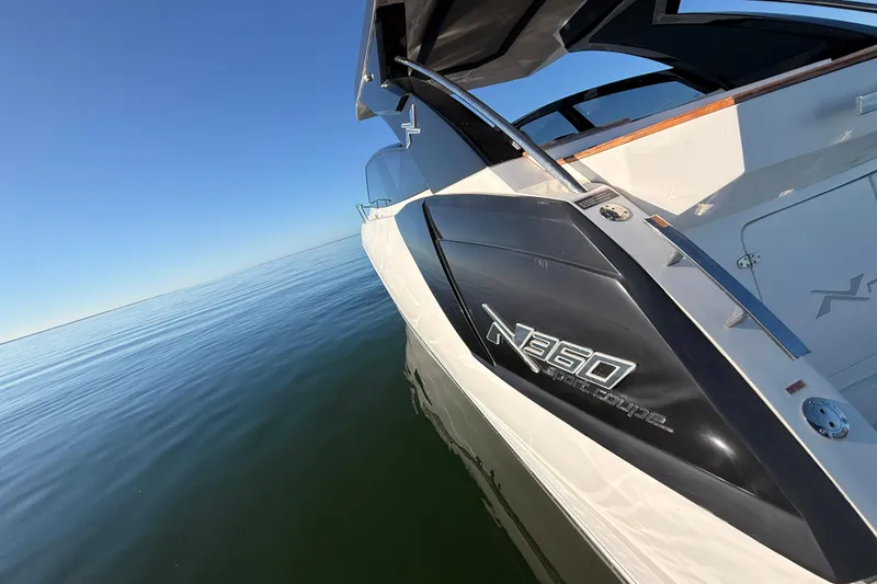 Slide: The Image of 2023 NX Boats 360 Sport Coupe on calm water, showcasing sleek design. - 64