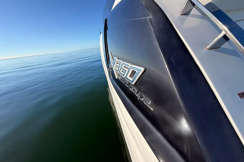 Slide: The Image of 2023 NX Boats 360 Sport Coupe on calm water, showcasing sleek design. - 66