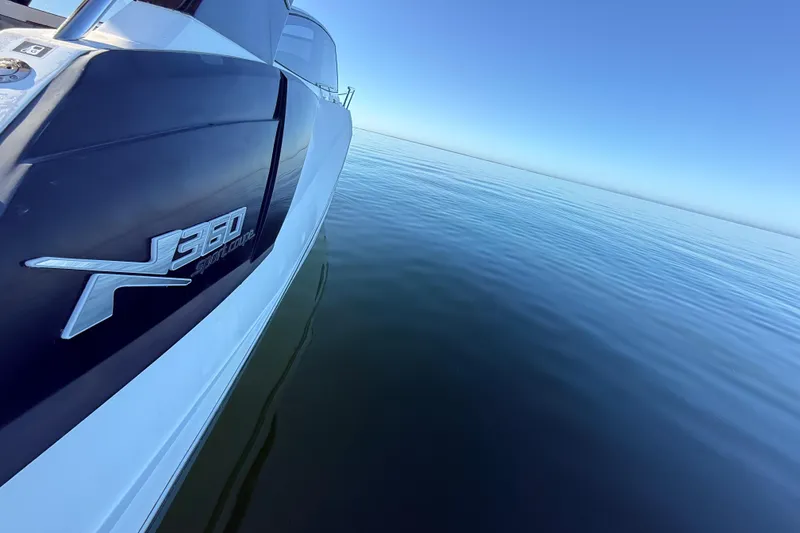Slide: The Image of 2023 NX Boats 360 Sport Coupe on calm water, showcasing sleek design. - 67