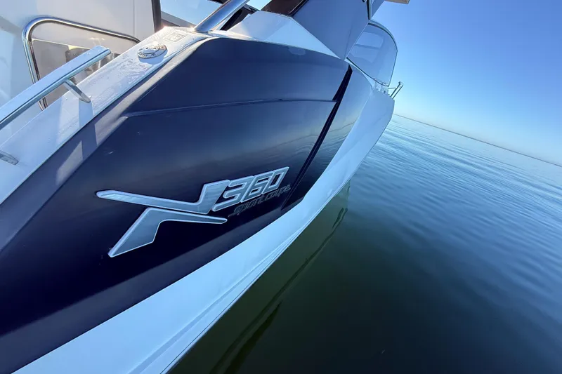 Slide: The Image of 2023 NX Boats 360 Sport Coupe on calm water, showcasing sleek design. - 68