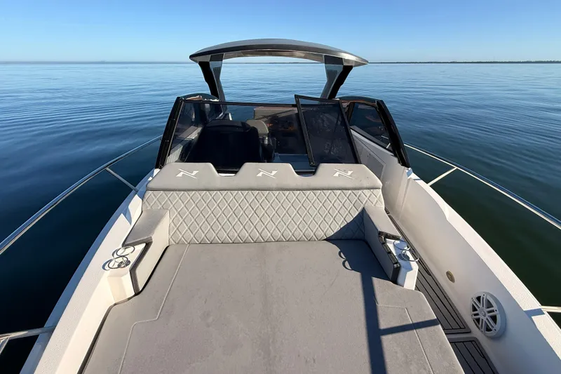 Slide: The Image of 2023 NX Boats 360 Sport Coupe on calm water, featuring sleek design and spacious deck. - 70