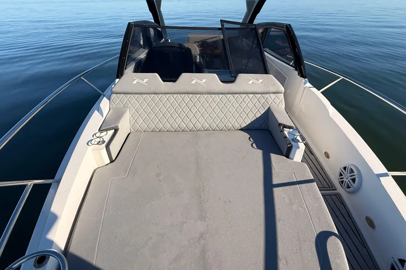 Slide: The Image of 2023 NX Boats 360 Sport Coupe deck with cushioned seating on calm water. - 71