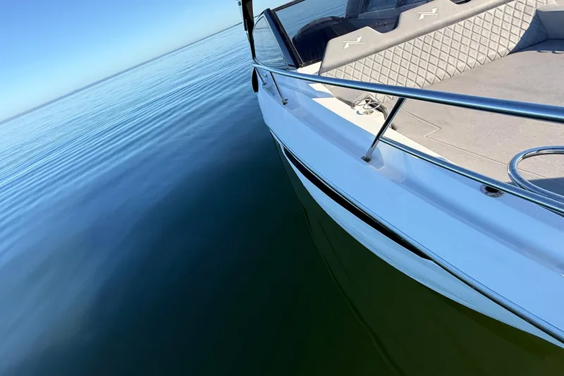 Slide: The Image of 2023 NX Boats 360 Sport Coupe on calm water, showcasing sleek design and luxury seating. - 72
